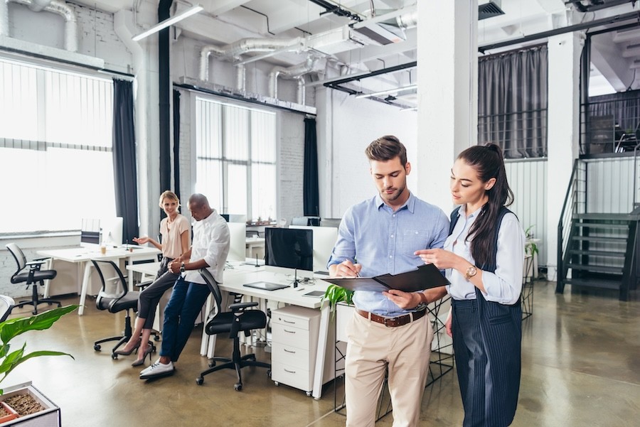 A group of people working in a brightly lit, open-concept office.